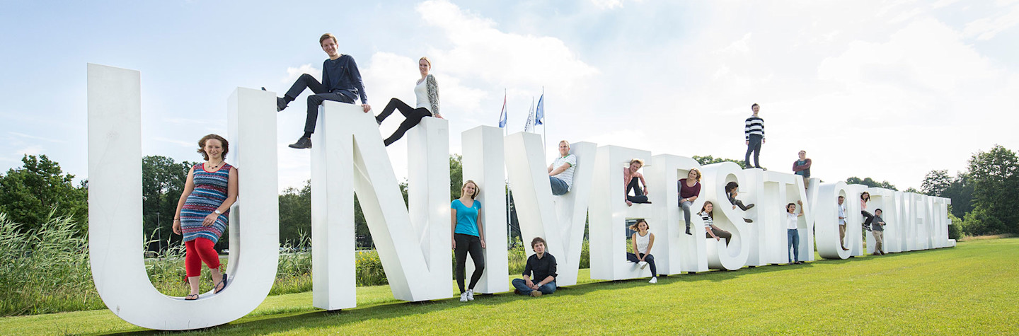 Levensgrote letters op de campus van de Universiteit Twente die de (Engelse) naam van de universiteit, University of Twente, weergeven.