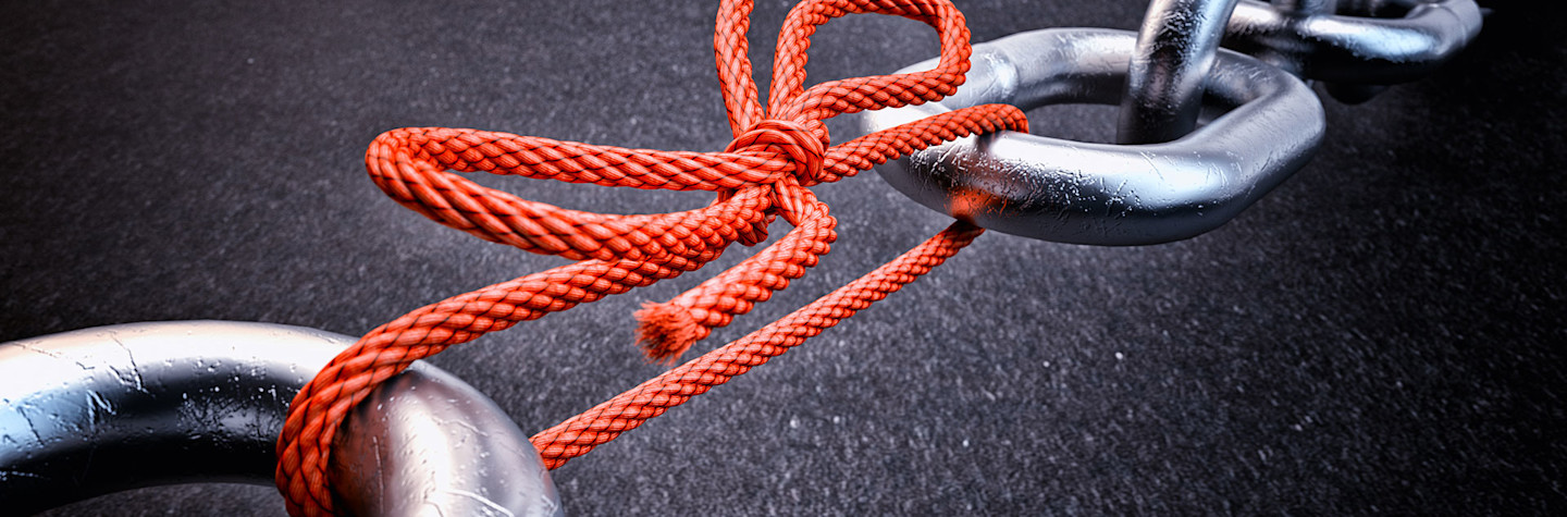 Metalen ketting verbonden door een rood geknoopt touw op zwarte achtergrond