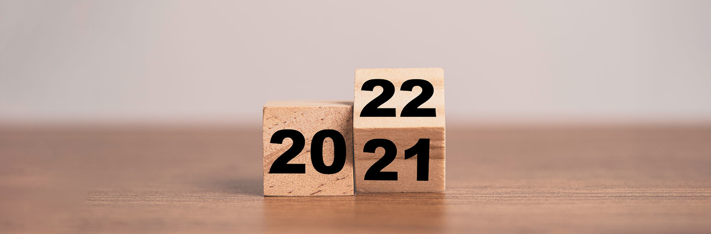 Flipping a wooden cube block to change the year 2021 to 2022.