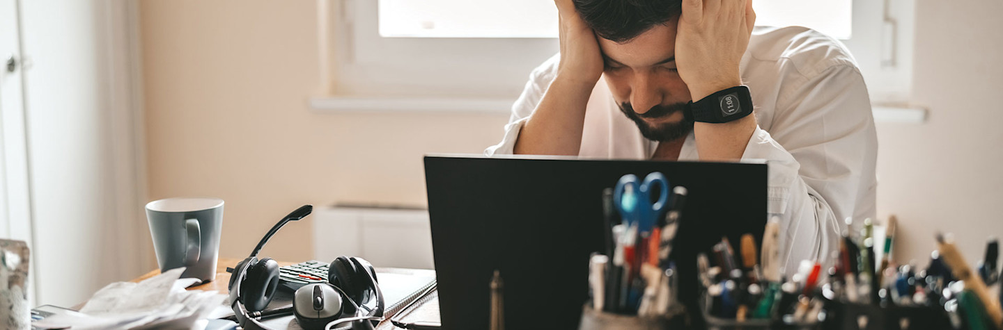 Tired, frustrated, exhausted employee at his desk