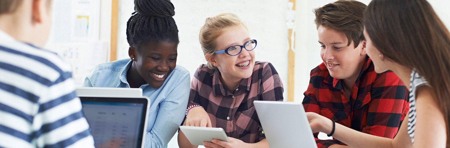 Group of teenage students working together on an IT project