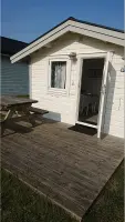 Camping cabin with two rooms. and two beds with possibility to add 2 more beds, kitchen furniture, trinket with fridge and stove. Shower and toilet in service building. Small terrace with garden furniture.