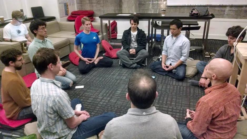 Michael Munson (in blue) meditates with other Hack Reactor students.
