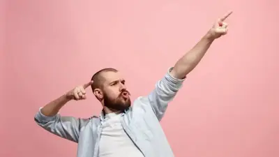 Hombre con gesto de idea señala hacia arriba sobre fondo rosa