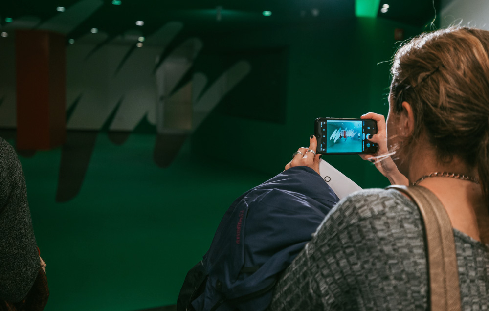 Una visitante de la muestra MANIFIESTO capturando con su celular la obra Tensión.