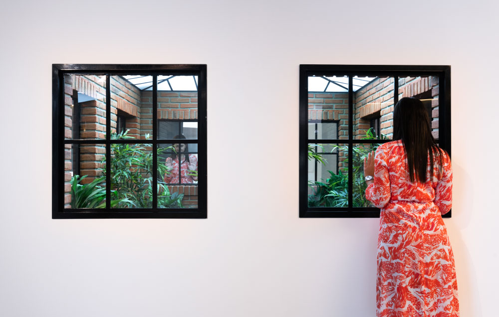 Visitante en la obra Lost Garden (2009), un juego de espejos en un jardín escondido en el hall central de Casa Naranja.