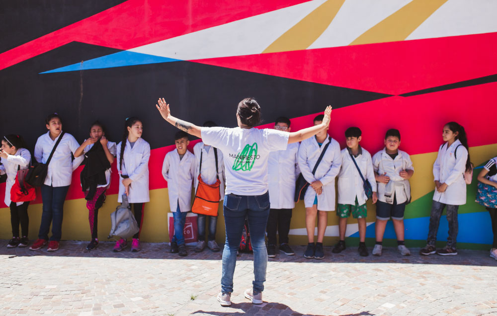 Alumnos participando de una visita educativa de la muestra Manifiesto guiada por el equipo de mediación de Casa Naranja