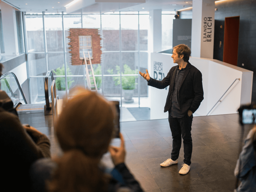 Leandro Erlich cecorriendo la exhibición con visitantes