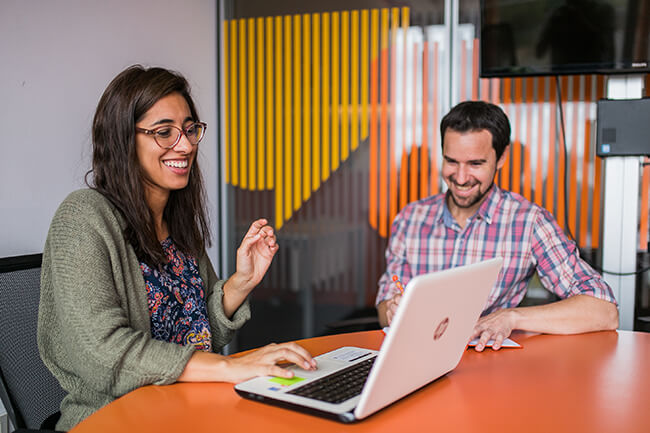 Dos colaboradores trabajando en las oficinas de Naranja