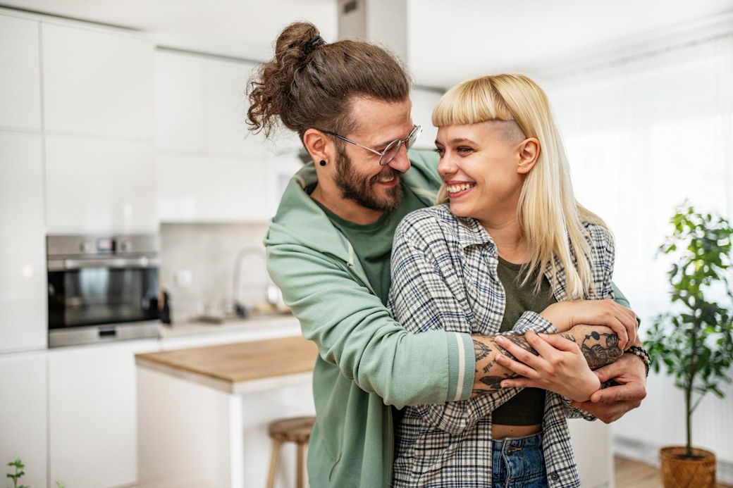 Glückliches Paar zu Hause umarmt.