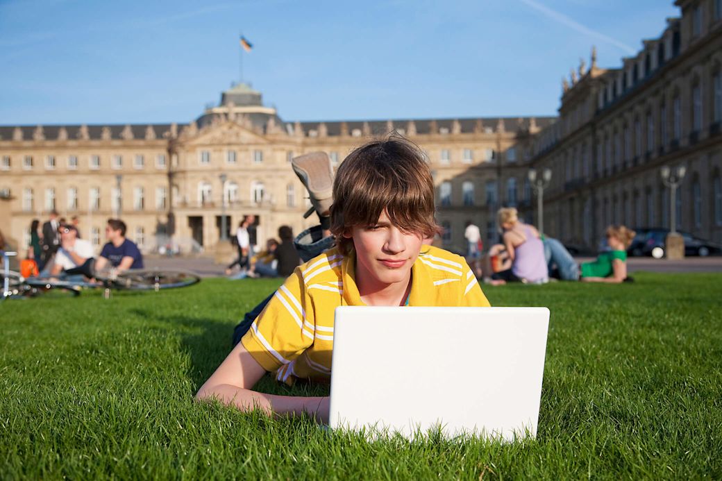 Dein Gasanbieter mit Klimabeitrag in Stuttgart Junger Mann am Laptop in Stuttgart am Schlossplatz