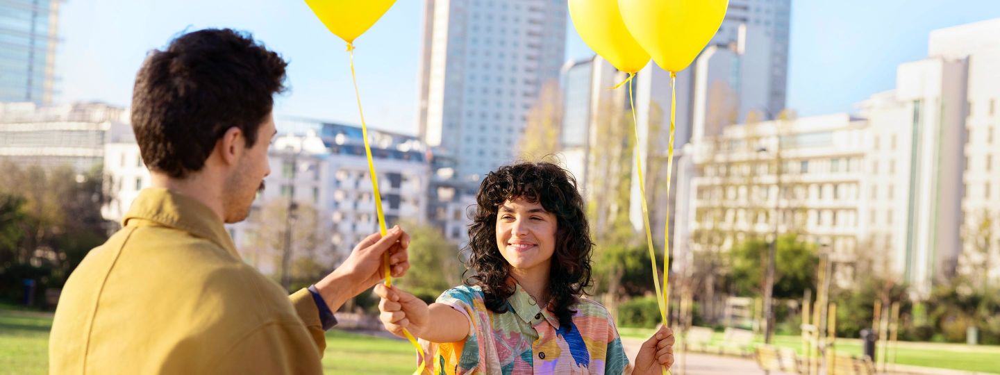 Frau schenkt ihrem Freund gelbe Luftballons