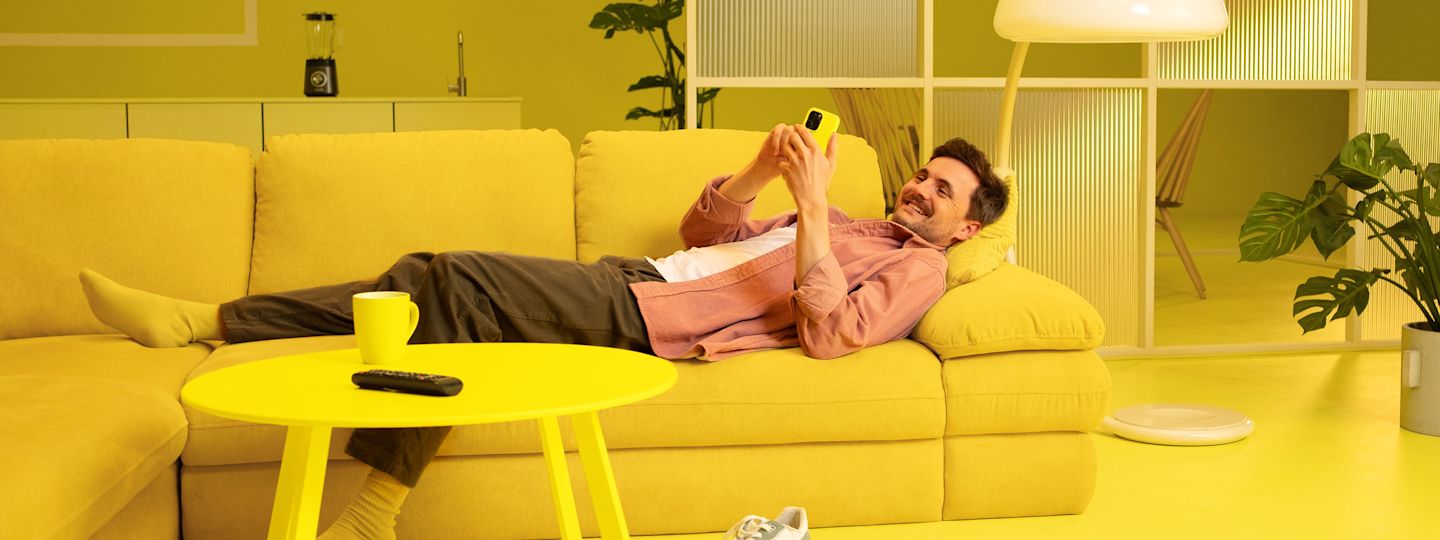 Unsere Services für dich. Junger Mann entspannt auf seiner Couch zuhause