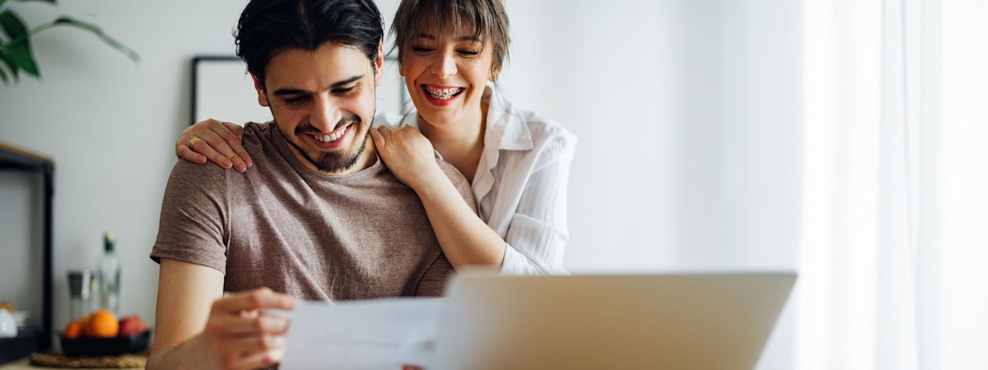 Erleb keine Überraschungen mehr bei deiner Abschlagszahlung Junges Paar prüft zusammen die Rechnung am Schreibtisch