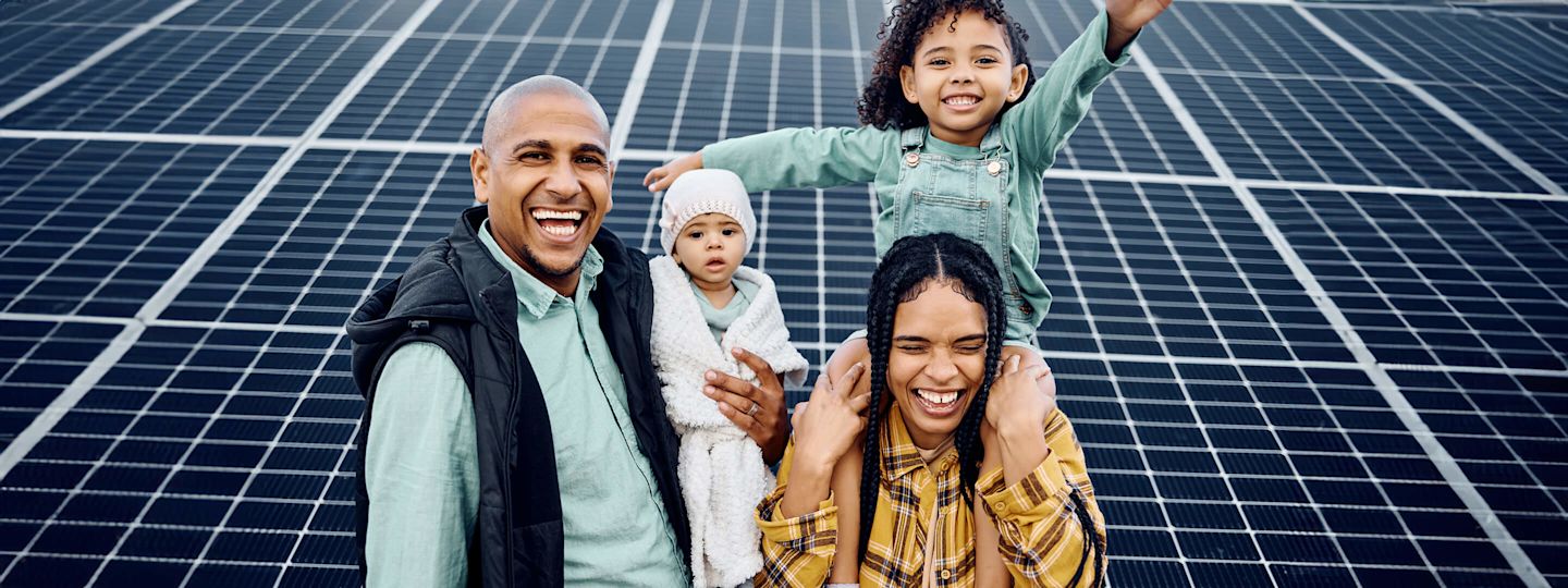 Vorteile einer Solaranlage für dein Zuhause Familie macht zusammen ein Foto vor Solaranlage