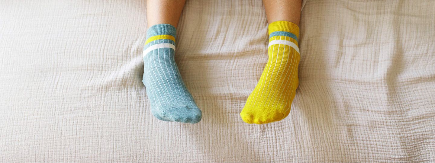 Wärmestromtarife: Perfekt für Wärmepumpe & Nachtspeicherheizung. Füße in Stricksocken unter der Bettdecke
