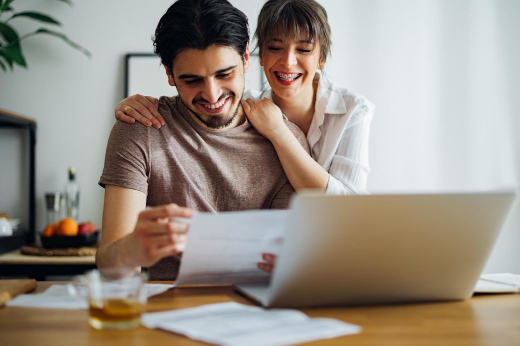 Behalt deine Energiekosten einfach im Blick – mit Yello Junges Paar vor Laptop prüft zusammen die Rechnung