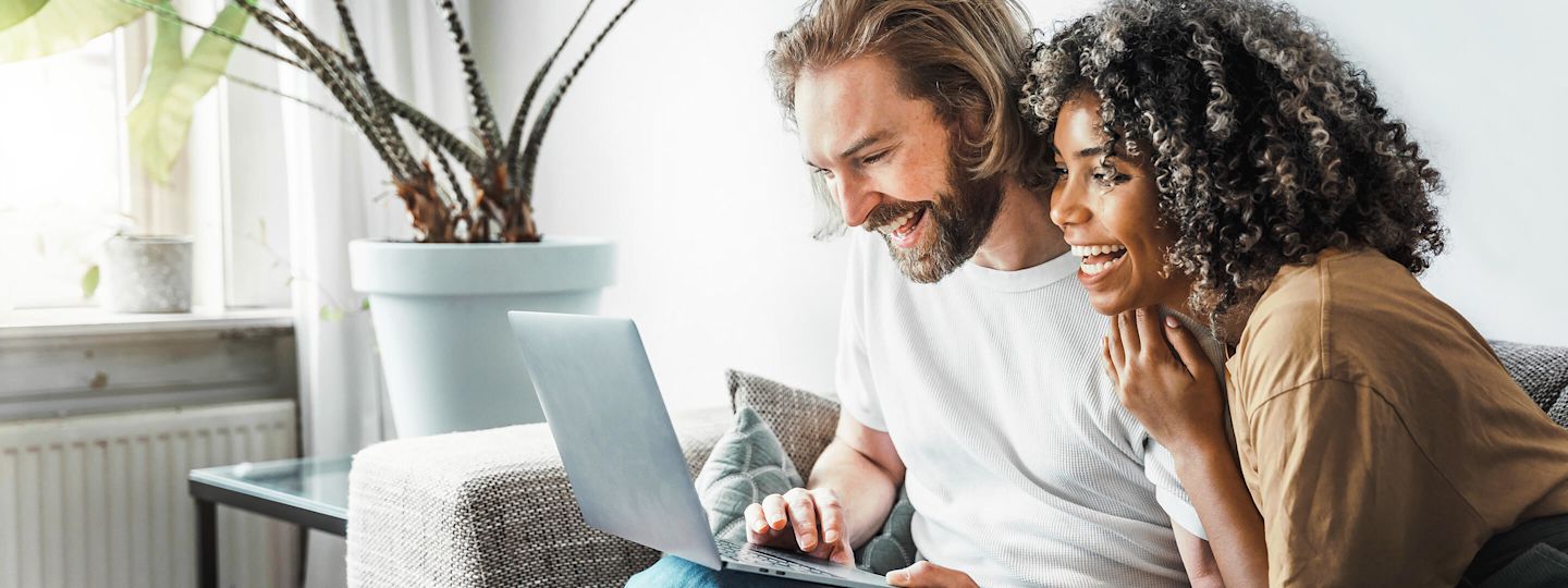Einfach Gas und Energie sparen mit Yello Glückliches Paar auf Sofa mit Laptop