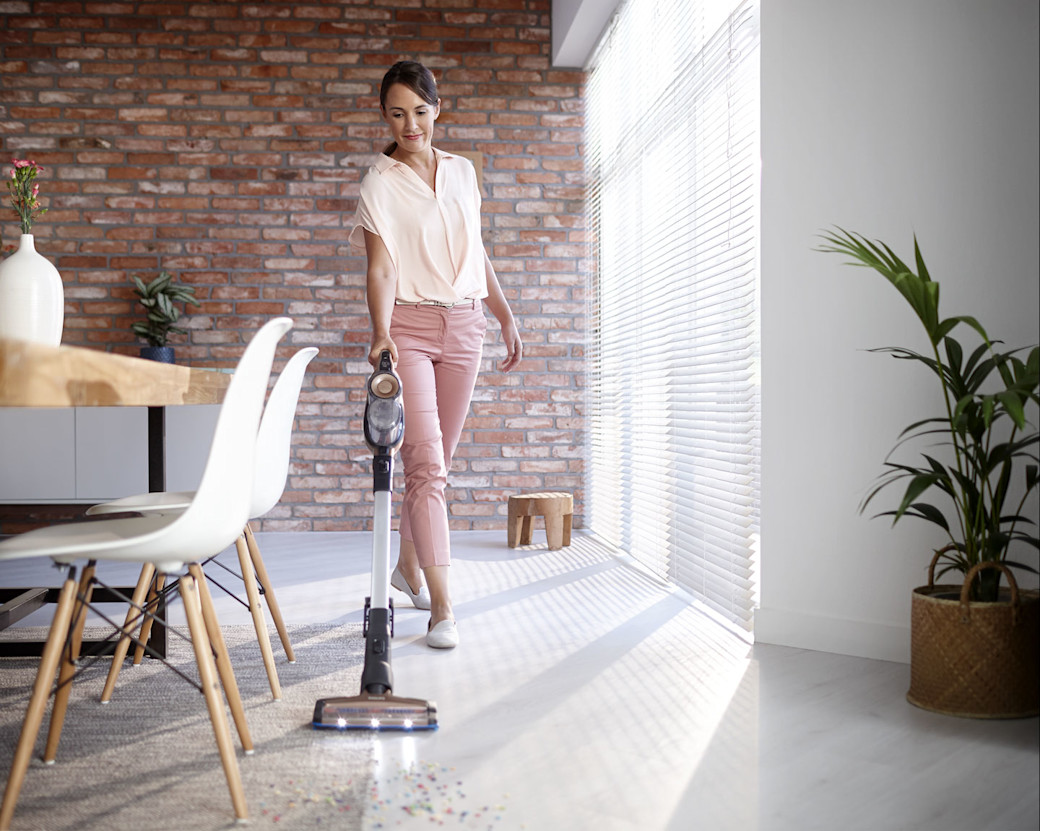 Philips Akkusauger SpeedPro Frau saugt Esszimmer