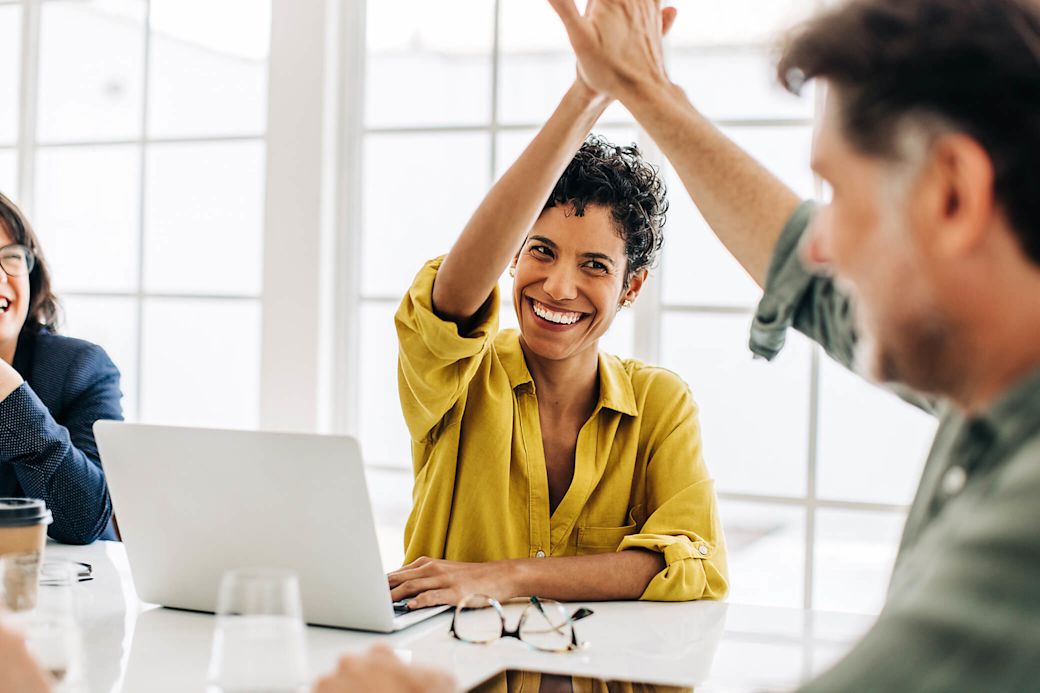 Erfolgreiche Zusammenarbeit im Büro für mehr gute Energie Frau und Mann geben sich High Five im Büro
