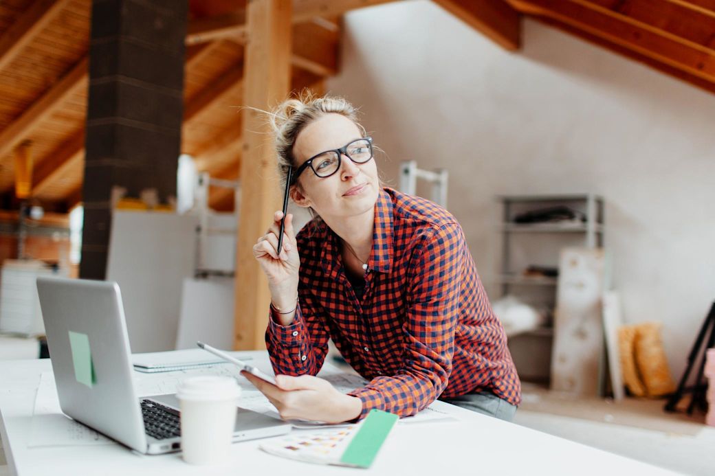Werden wir den Umstieg auf erneuerbare Energien schaffen? Frau sitzt zuhause nachdenklich am Laptop
