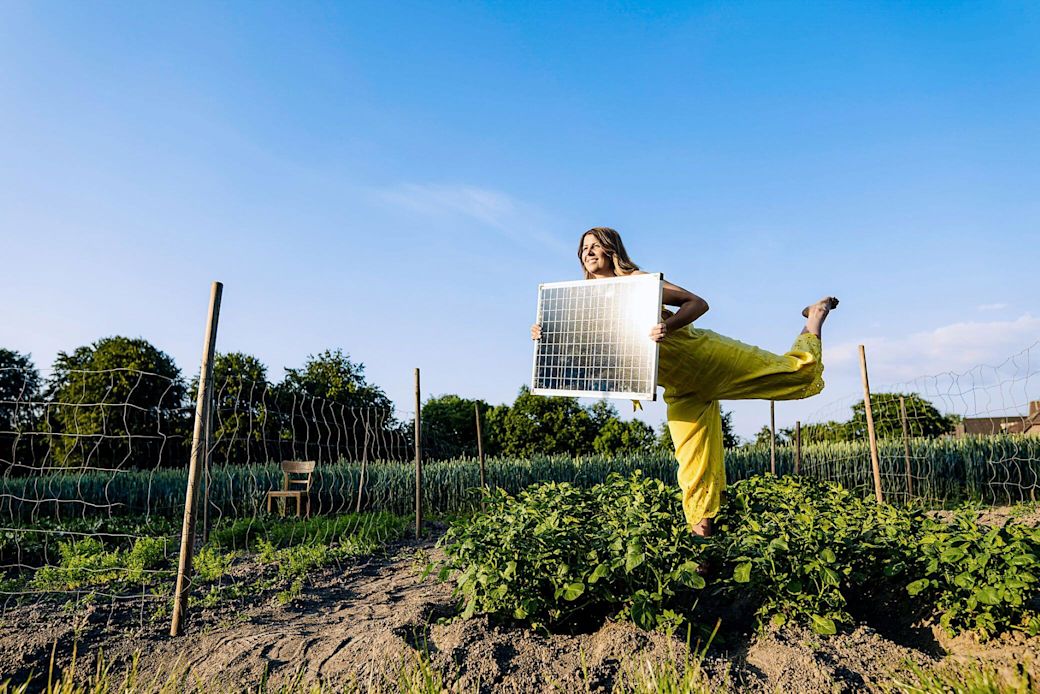 Mach es dir grün mit einer kleinen PV-Anlage zuhause Frau mit Solarmodul in den Händen im Garten