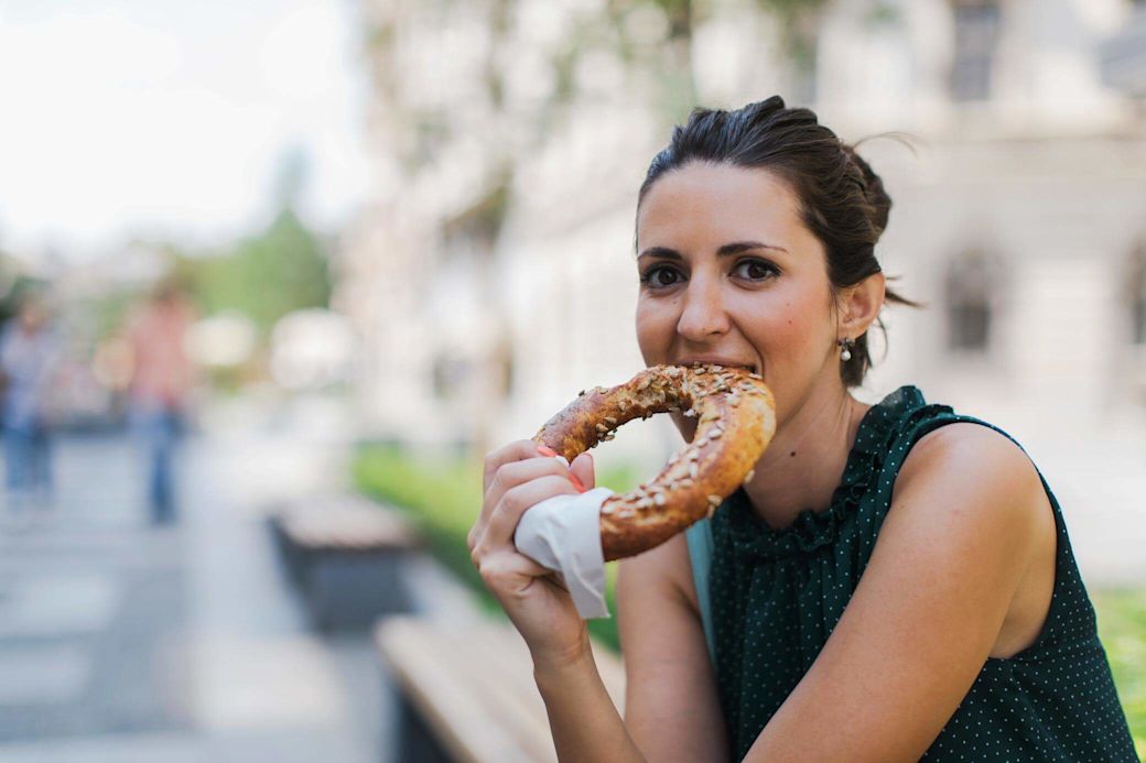 Jetzt Gasanbieter wechseln - in München Eine Frau isst eine Brezel in der Stadt