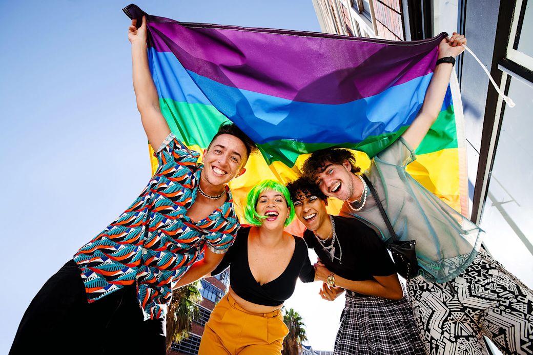 Bei Yello sind wir bunt - so wie deine Stadt Freunde halten zusammen eine Regenbogenfahne hoch