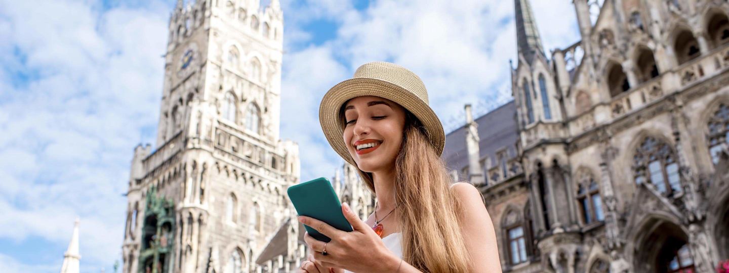 Gasanbieter für Münchner:innen Frau schaut auf ihr Handy am Marienplatz in München