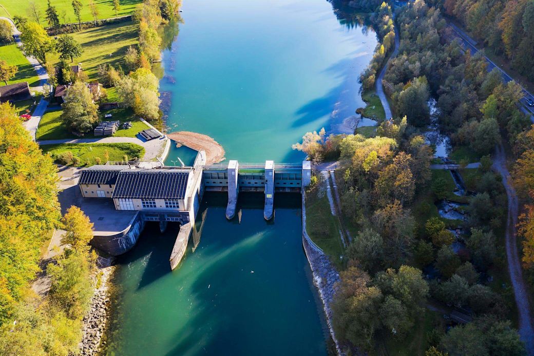 Deutsches Wasserkraftwerk aus Vogelperspektive Wasserkraftwerk in Bayern von oben mit grünem Fluß Isar und Bäumen am Ufer