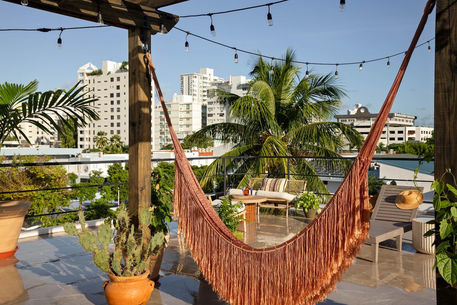The rooftop terrace and hammock at Maru by DW in Condado, with the neighbourhood's towers behind.