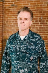 An older member of the U.S. navy in uniform who has VA benefits