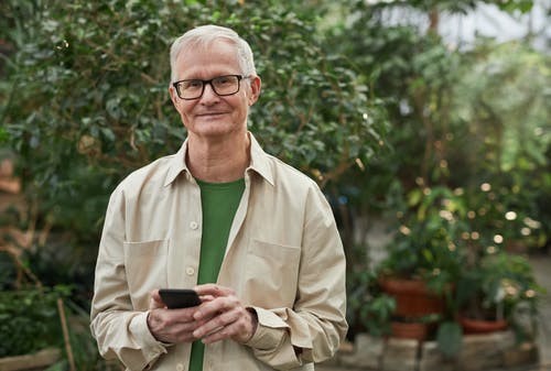 A older man looking for a five-star prescription drug plan on his phone.