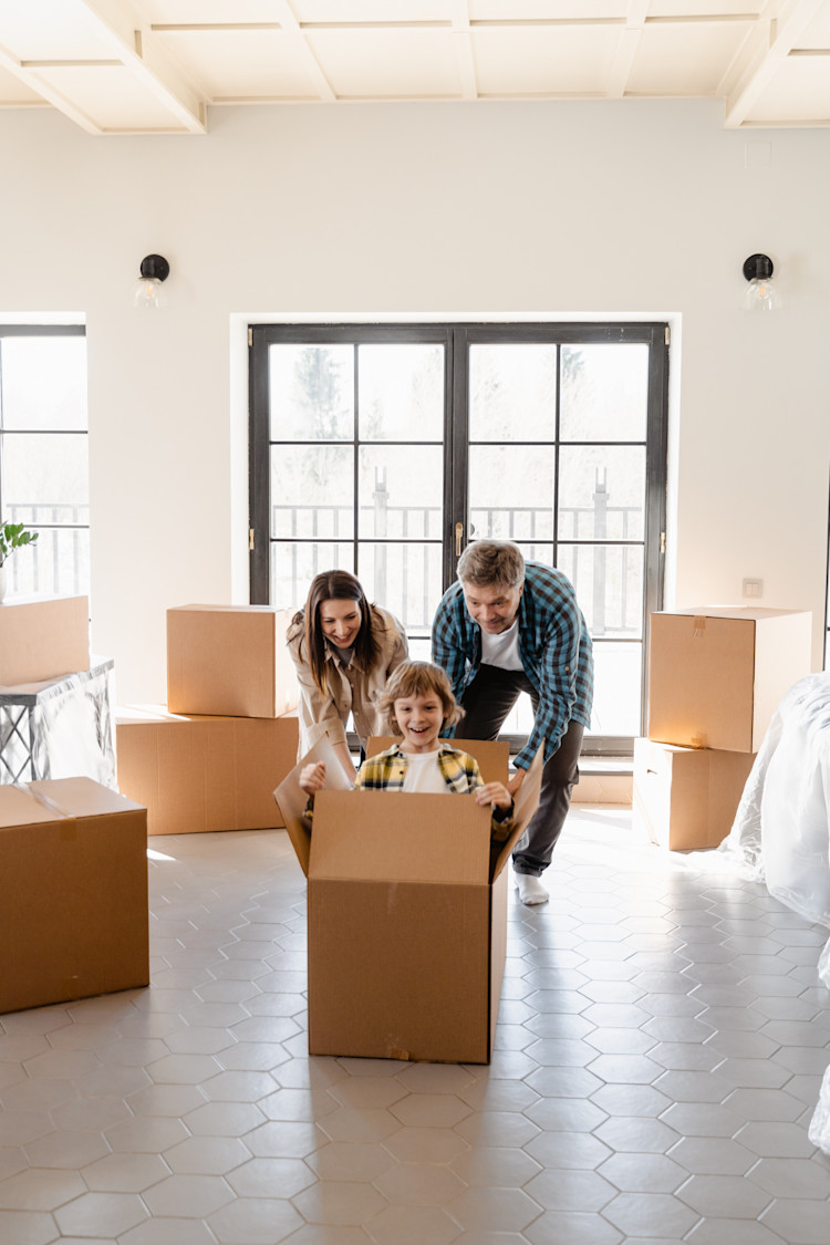 Man and Woman pushing child into box in newly purchased house after passing home inspection