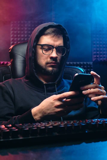 https://www.pexels.com/photo/a-man-in-black-hoodie-sweater-using-his-mobile-phone-6963096/