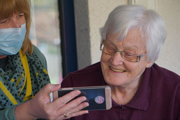 An insurance agent showing an elderly lady the nursing home costs.