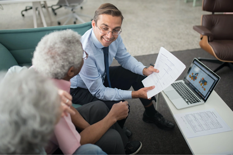 An insurance agent explaining how much life insurance the old couple needs.