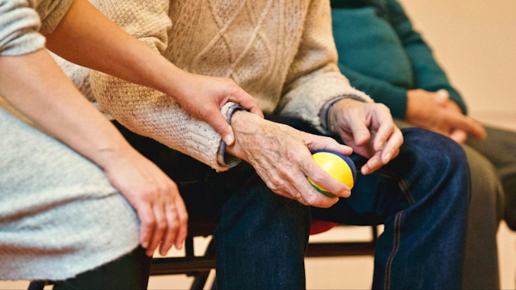 An elderly man receiving care in a nursing home.