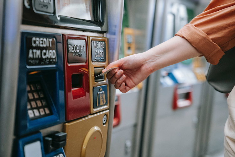 Person entering their card into an ATM where skimmers can be attached to steal card numbers and details