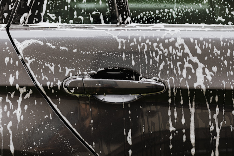 A car side door being washed that is covered by a car insurance policy