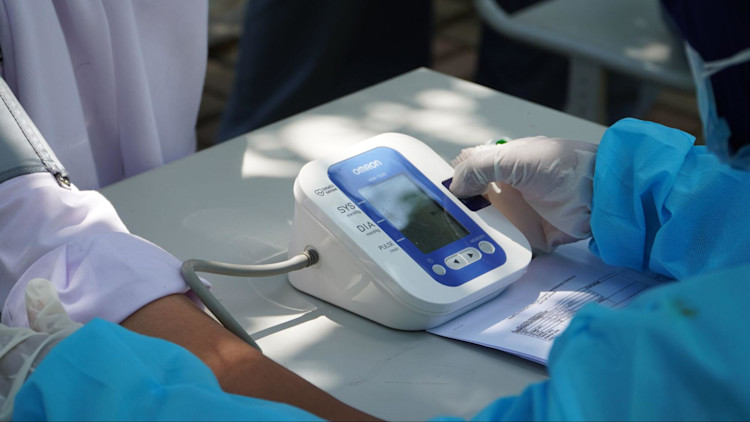 A doctor checking the blood pressure of a Life Insurance client.