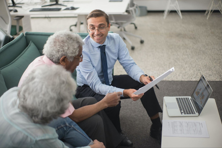 An elderly couple signing up for Voluntary Life Insurance.