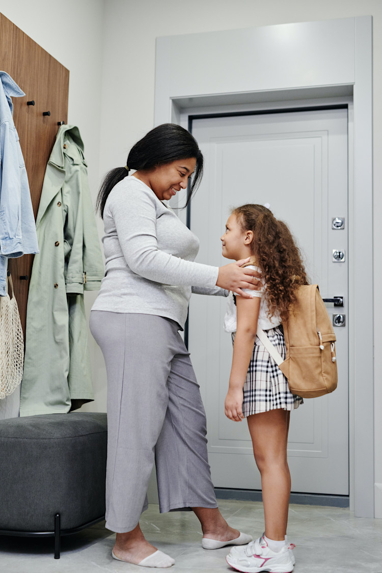 Photo of adult talking to their child before school