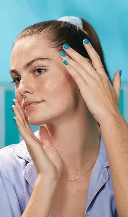 Giovane donna con il viso idratato e radioso in bagno