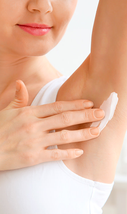 La giovane donna applica la crema sull'ascella