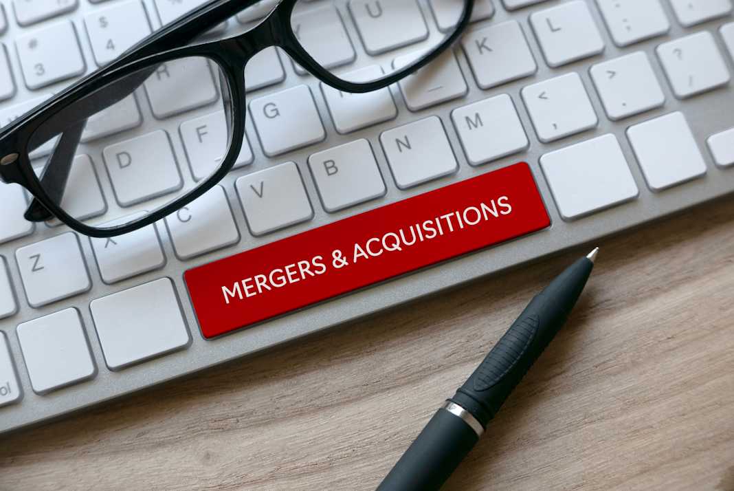 keyboard with the words mergers & acquisitions written on it