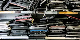 Piles of old discarded laptops on a shelf (Source: Daniel Allan/Image Source via Getty Images)