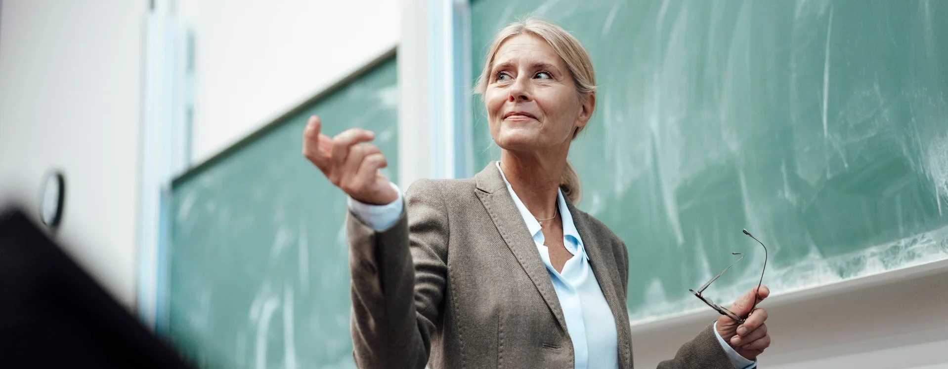 Businesswoman giving presentation by chalkboard at convention center