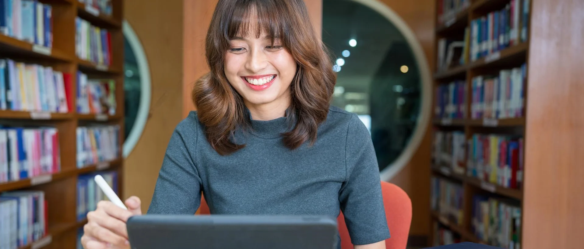 Asian woman student video conference e-learning with teacher on digital tablet at library. Back to school education knowledge college university concept. Young women working and used digital tablet. GettyImages-2148719539.jpg