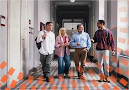 College teacher and students walking down hallway